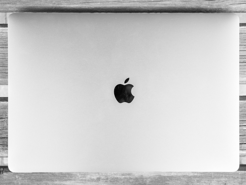 Apple M4 - Apple Macbook spoczywający na drewnianej ławie